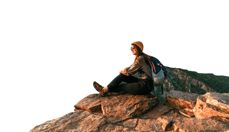 Mulher sentada na pedra observando a paisagem